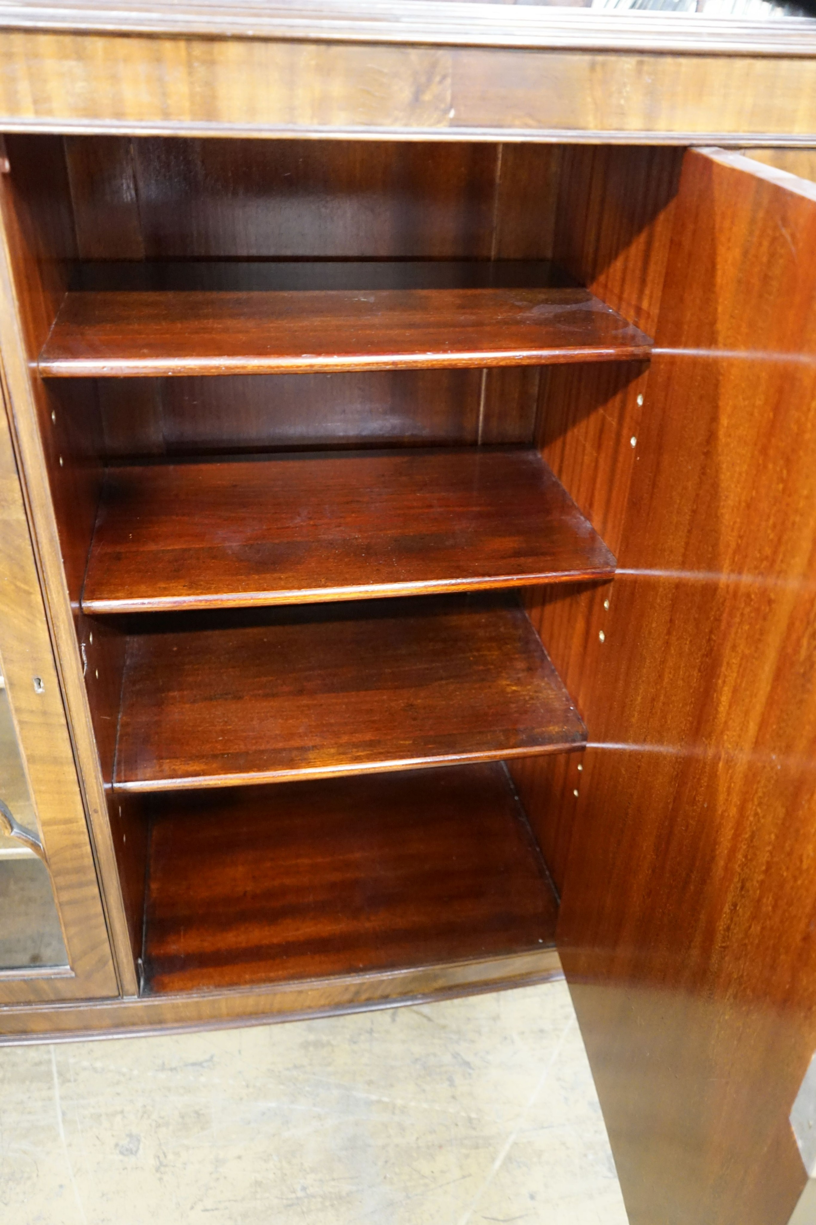 A 1920's mahogany bow front bookcase, width 152cm, depth 39cm, height 116cm